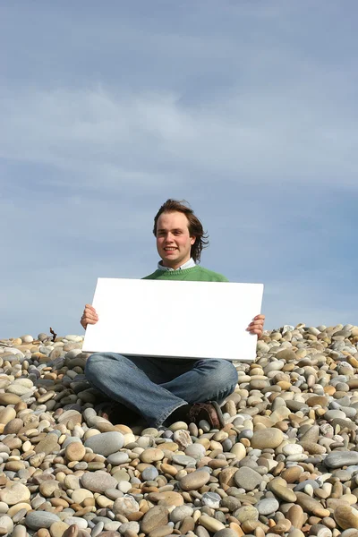 该名男子在海滩上手持白卡 — 图库照片