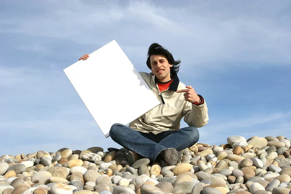 Homem segurando cartão branco na praia — Fotografia de Stock