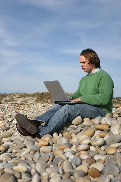 Hombre casual con portátil en la playa — Foto de Stock