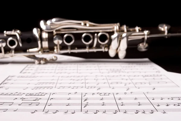 Clarinet isolated over sheet music — Stock Photo, Image