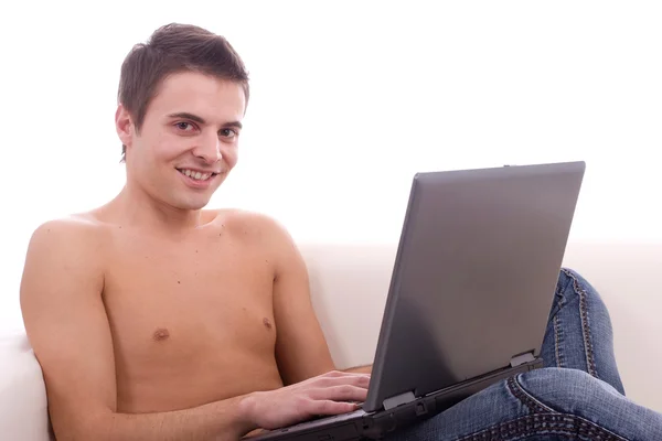 Gutt som jobber med laptop på sofaen – stockfoto
