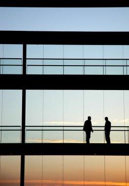 gün batımında bina siluet içinde iki işçi