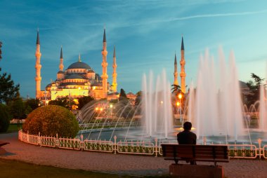 Man sitting on a bench near blue mosque clipart