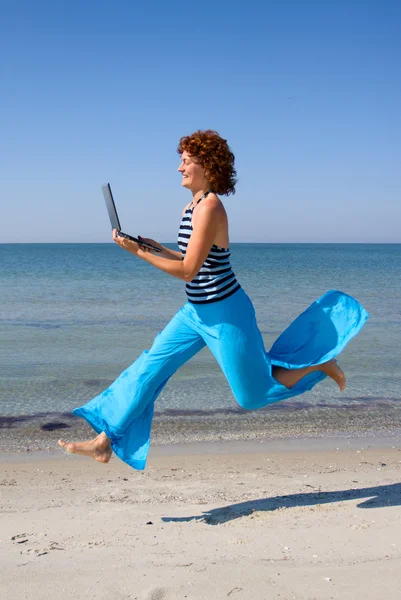 ラップトップ コンピューターで走っている女性 — ストック写真