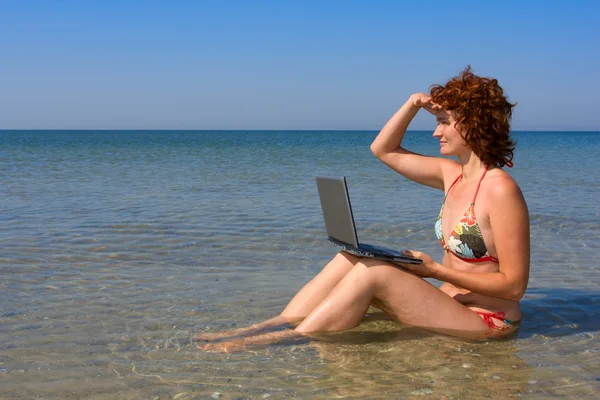 Chica con ordenador portátil en el mar — Foto de Stock