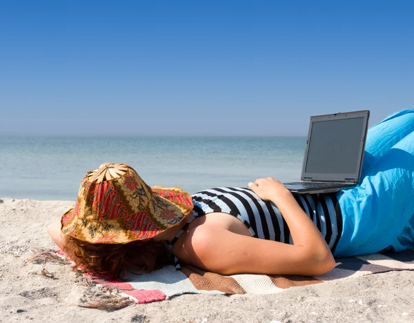Flicka sova med laptop på stranden — Stockfoto