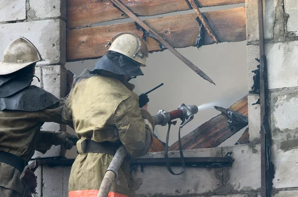 Feuerwehr löscht brennendes Haus — Stockfoto