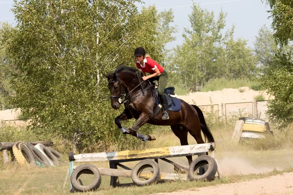 Womanl op paard springen over barrière — Stockfoto