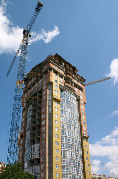 Building under construction and hoisting crane