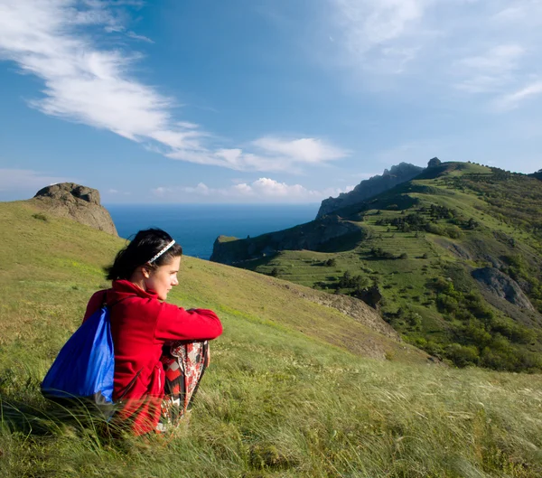Κοπέλα καθόταν πάνω σε ένα λόφο πάνω από την θάλασσα — Φωτογραφία Αρχείου