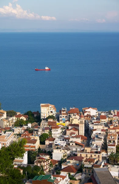 Pequeña ciudad junto al mar y barco en el mar — Foto de Stock
