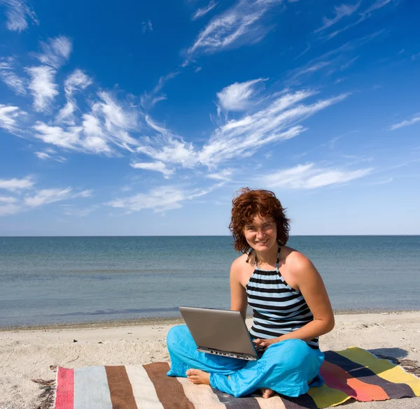 Fille avec ordinateur portable à la côte de la mer — Photo