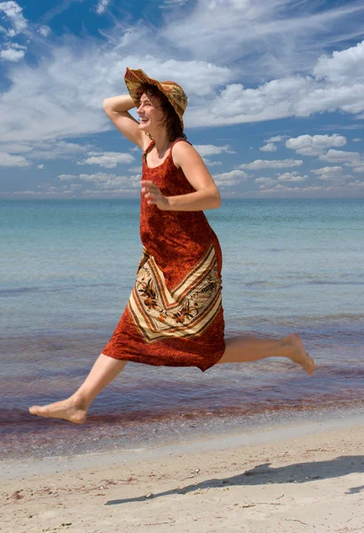 Κορίτσι με το καπέλο που τρέχει στη θάλασσα παραλία — Φωτογραφία Αρχείου