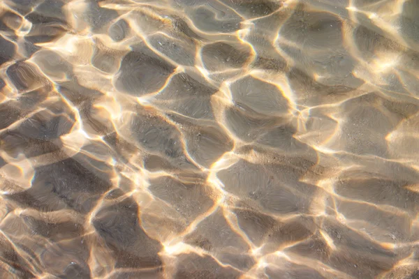 Sonne tanzt auf dem Wasser am Sandstrand — Stockfoto