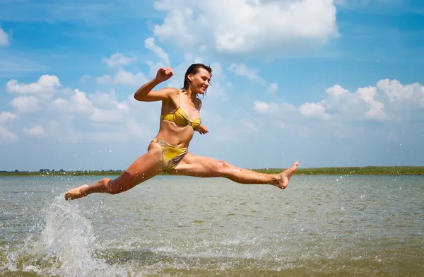 Дівчина стрибає над озером — стокове фото