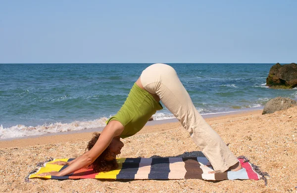 Flicka i adho mukha svanasana yoga utgör — Stockfoto