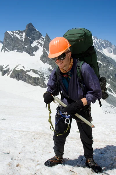 Turuncu kask içinde mutlu dağcı — Stok fotoğraf