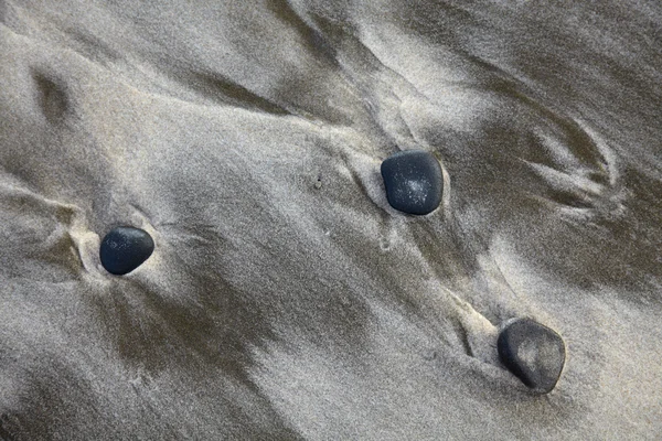 Drie stenen op zand — Stockfoto