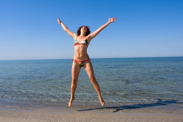 Женщина прыгает на море — стоковое фото