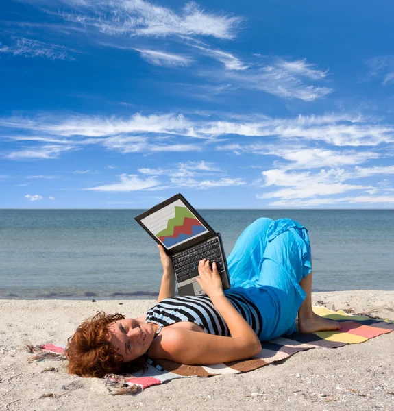 Dziewczyna pracuje na laptopie w pobliżu morza — Zdjęcie stockowe