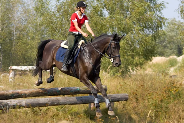 Vrouw op springen paard — Stockfoto