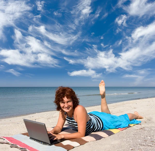 Frau mit Laptop am Meeresstrand — Stockfoto