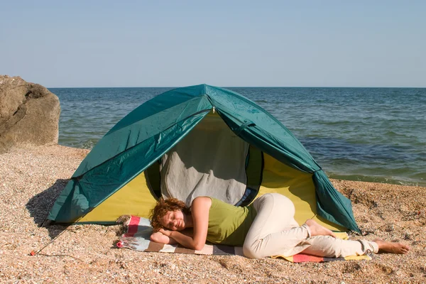Donna dormire vicino alla tenda al mare — Foto Stock