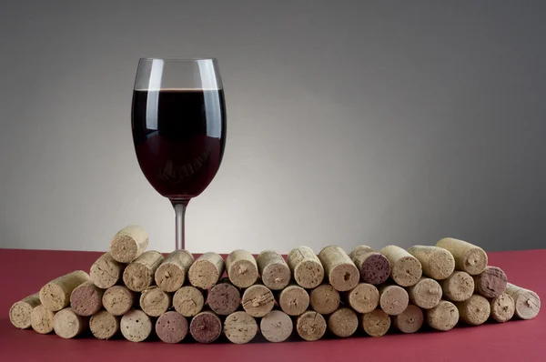 Red wine glass and corks. — Stock Photo, Image