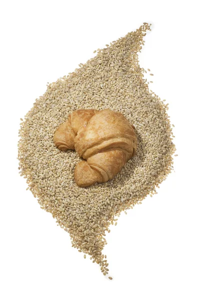 Croissant over grains — Stock Photo, Image