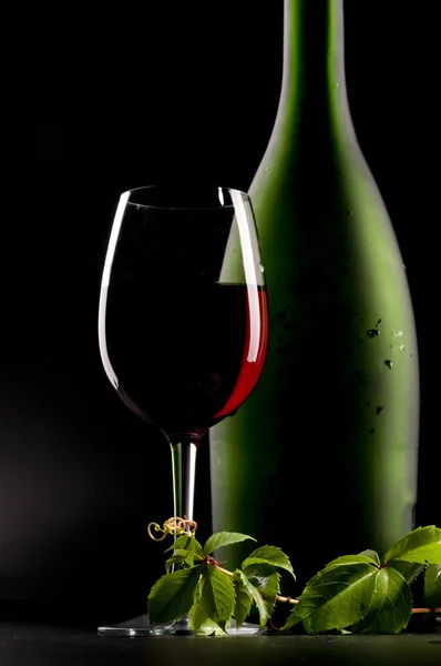 Красное вино и бутылка натюрморта — стоковое фото