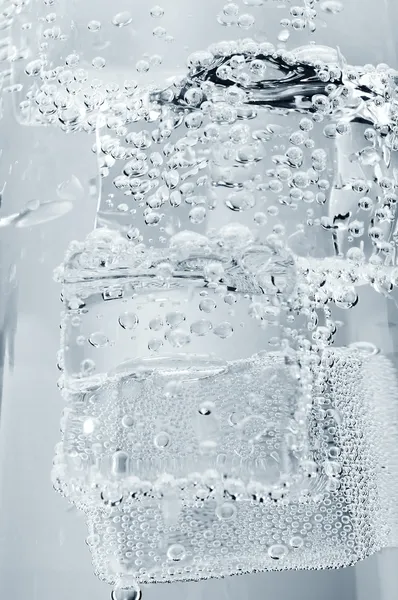 Кубики льда в стакане минеральной воды — стоковое фото