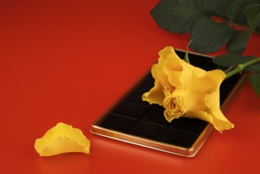 Black chocolate and a yellow rose. clipart