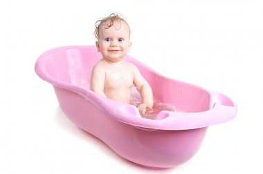 Baby girl bathing in the bath clipart