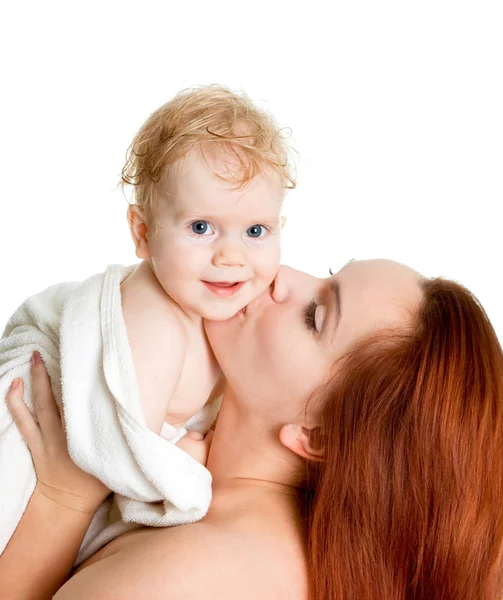 Мать целует девочку в полотенце на корме — стоковое фото