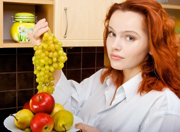 Mujer poniendo uvas en un plato con fru —  Fotos de Stock