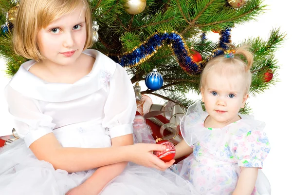 Dívka dává vánoční koule její sestra — Stock fotografie