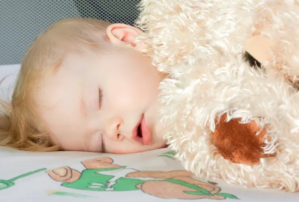 Retrato de um bebê adormecido com um brinquedo — Fotografia de Stock