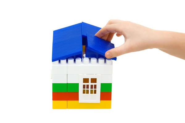 Hand puts the roof on the house Royalty Free Stock Images