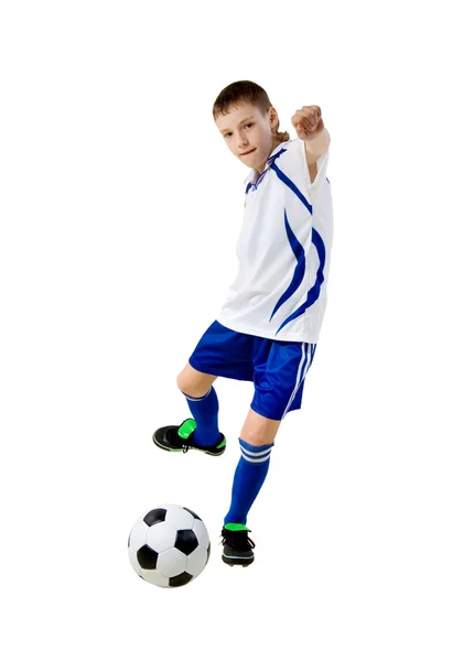 Pojke en fotbollsspelare slår på en boll — Stockfoto