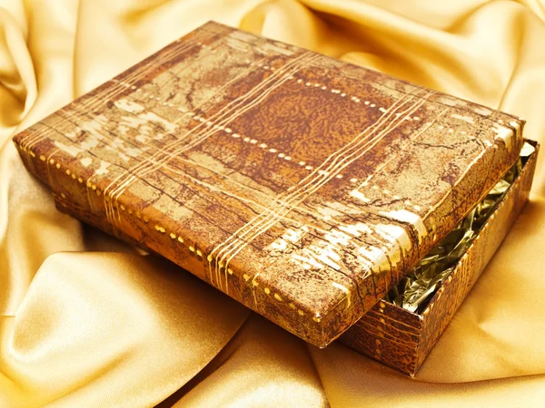 Presente em tecido dourado — Fotografia de Stock