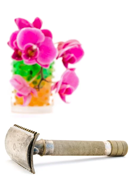 Orchidea az üveg és a borotválás borotva — Stock Fotó