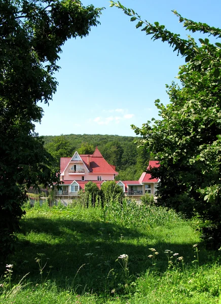 stock image Cottage in a frame of green trees