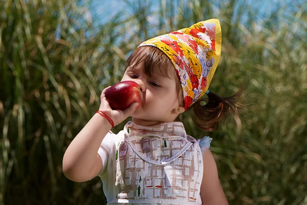 小さな女の子は桃を食べる — ストック写真