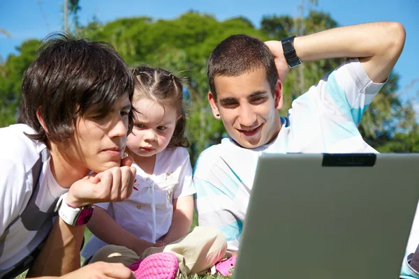 Два парня и маленькая девочка с ноутбуком — стоковое фото