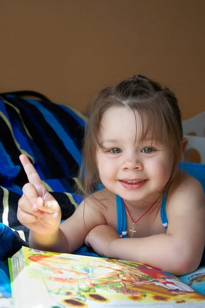Schönes kleines Mädchen auf dem Bett liegend — Stockfoto
