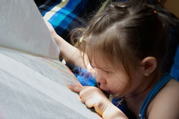 Gyönyörű kicsi lány az ágyon, és az olvasás — Stock Fotó