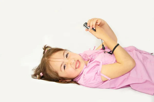 Liten flicka med en mobiltelefon — Stockfoto