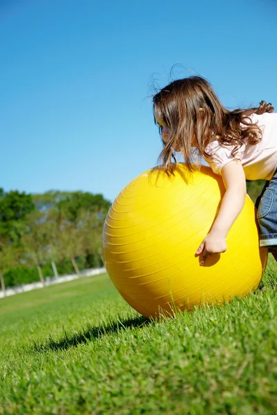 Mädchen spielen mit gelbem Ball — Stockfoto