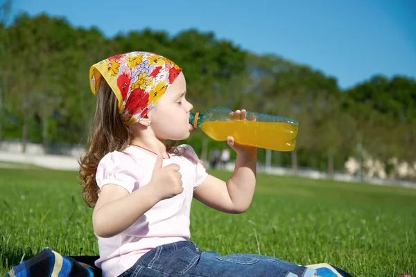 Маленька дівчинка п'є сік — стокове фото