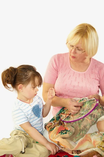 Бабушка и внучка вышивают — стоковое фото